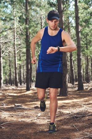 25281102-man-looking-at-stopwatch-to-check-gps-pace-and-time-on-trail-run